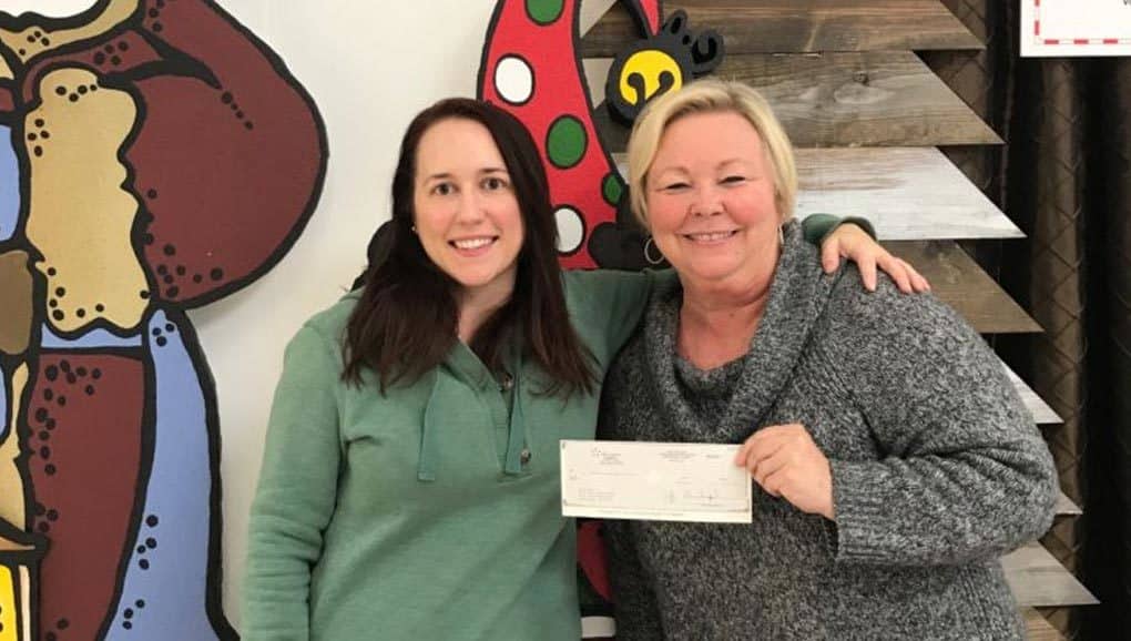 Two ladies showing donation check